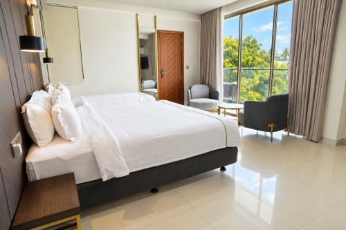 Deluxe Family Room with two beds and a sitting area by the window