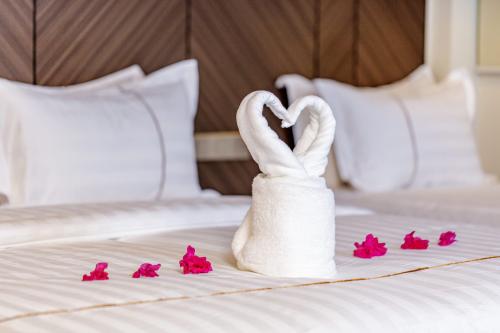 Towel swans and flowers on the bed at Royal Villa Fulidhoo